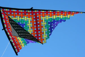 Real colorful custom delta kite flying against a blue sky