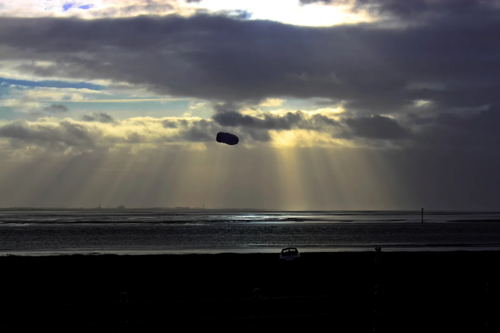 Real kite flying above a beach under a dramatic sky